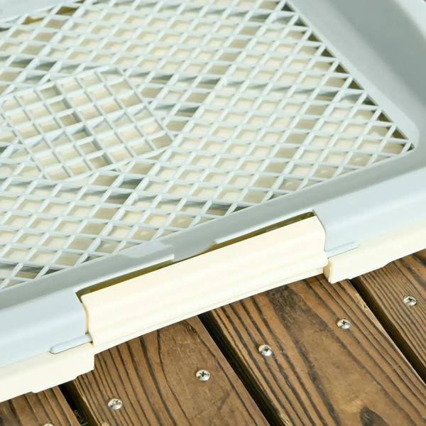 Close-up of the white grid panel inside a puppy training pad tray