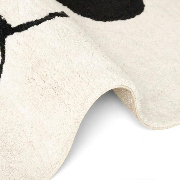 Close-up of a textured white rug with black abstract design
