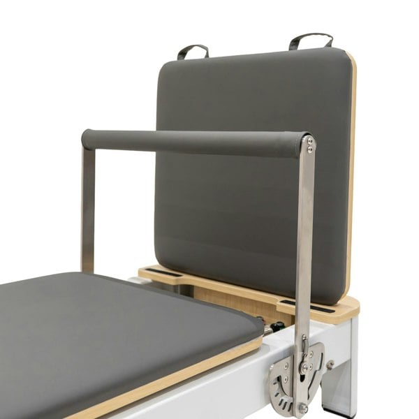 Aluminium Pilates reformer machine with a padded gray platform, adjustable headrest, and sturdy metal frame for stability