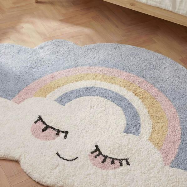 Cloud-shaped rug with a rainbow and smiley face on a wooden floor