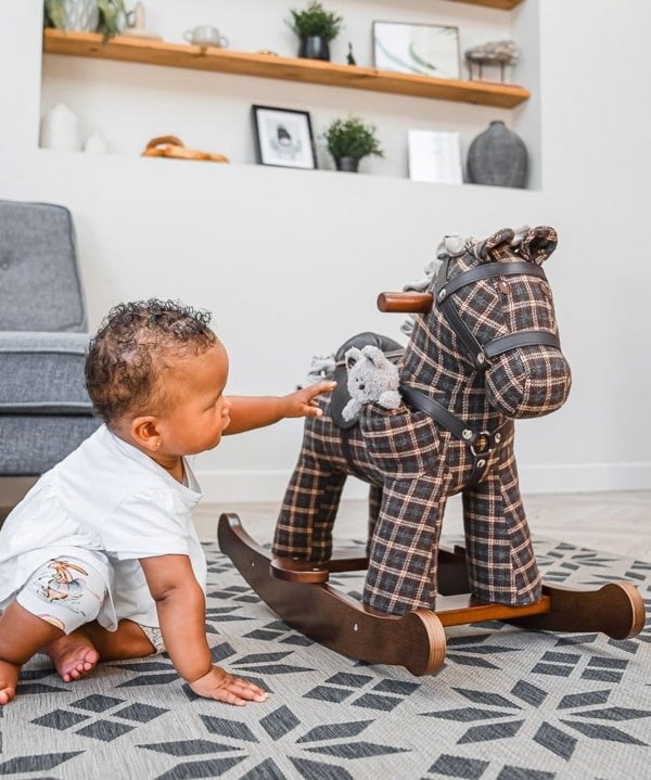 Little girl playing with ted bear from Ride on toy horse