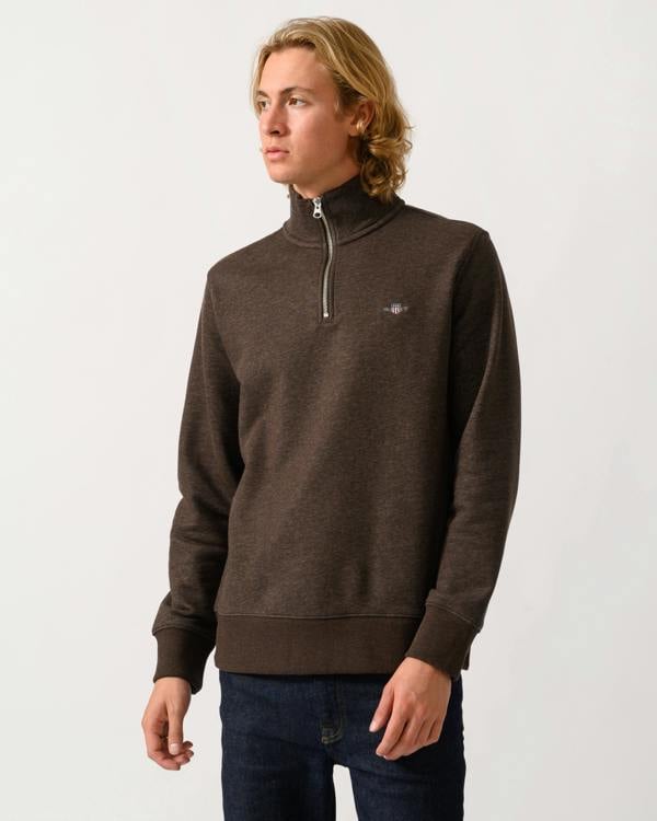model wearing a GANT Mens Regular Fit Shield Logo Half Zip Sweatshirt in 284 Black Brown Melange