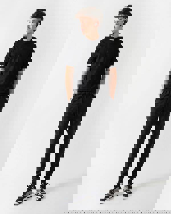 full length shot of a model wearing Tommy Hilfiger Mens Track Joggers in Black