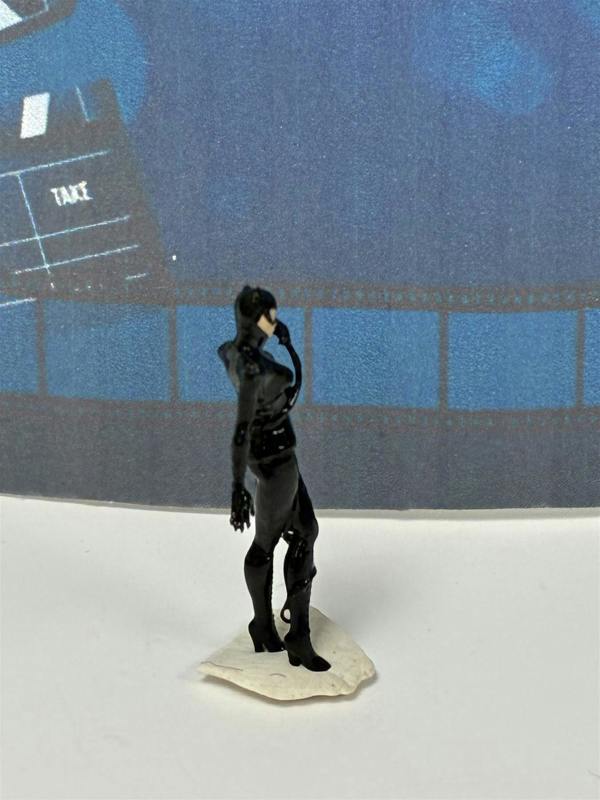 a toy figure of a woman in a black garment