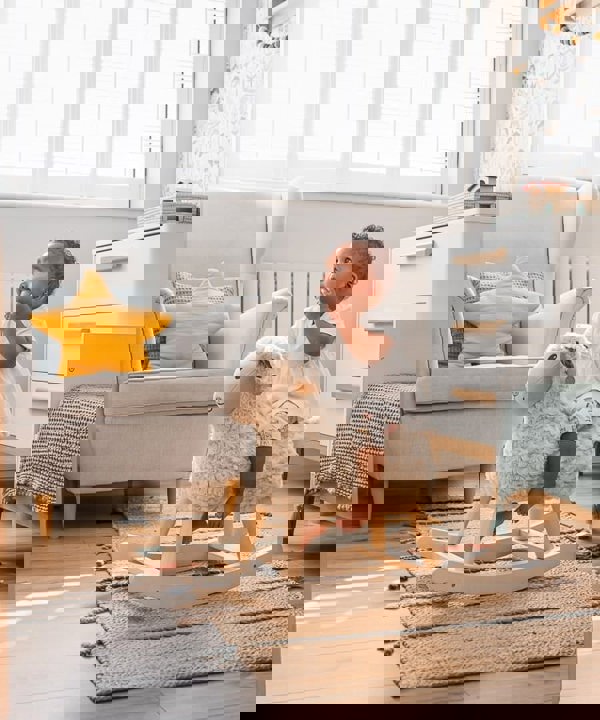 Little girl riding lambert childrens riding horse in nursery room 