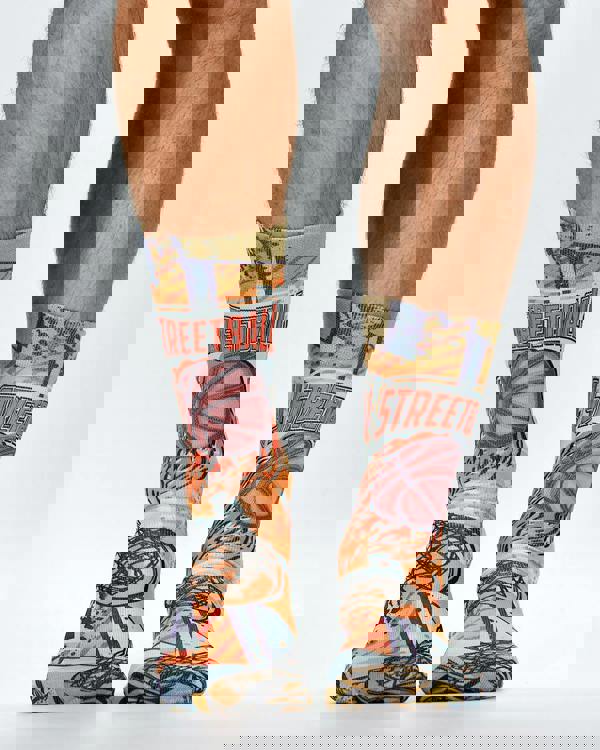 Colorful socks with basketball design worn by a person on a white background