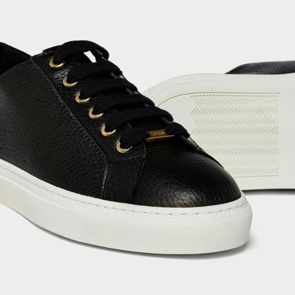 Black leather sneaker with white sole on a light gray background