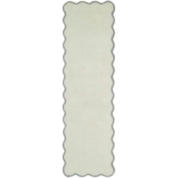 Rectangular white rug with scalloped edge on a white background