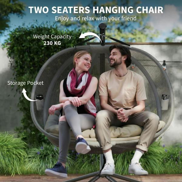 Double hanging egg chair with grey mesh pod and beige seat cushion on black stand.