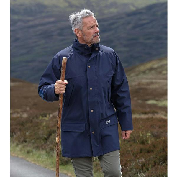 Man walking with a hiking staff whilst wearing the Hoggs of Fife Green King II waterproof jacket in navy blue