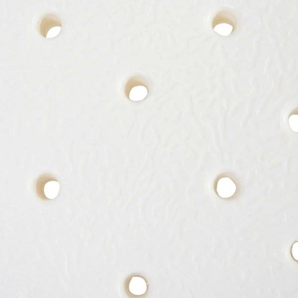 White shower stool seat surface close-up with evenly spaced drainage holes.