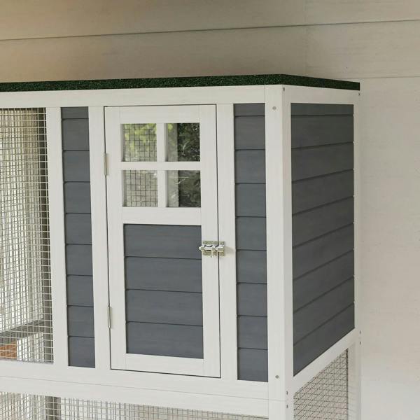 White outdoor cat enclosure side view with dark gray siding panels and a front door