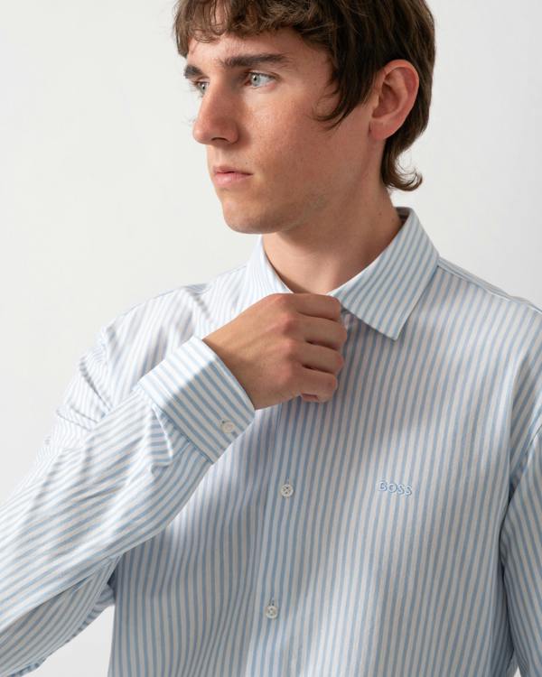 close up of a model wearing a BOSS Orange Mysoft Mens Slim-Fit Shirt in Melange Cotton Jersey in Open Blue 461