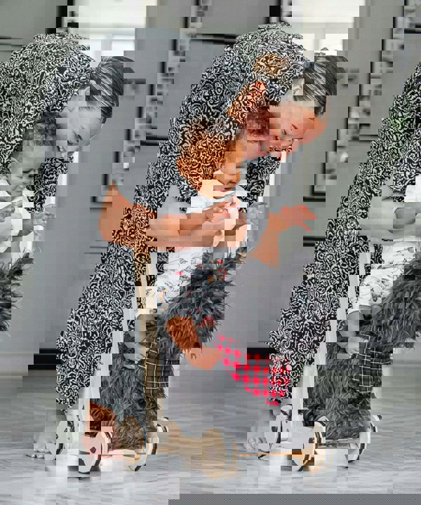 Mum putting baby onto scottie dog push along ride on 