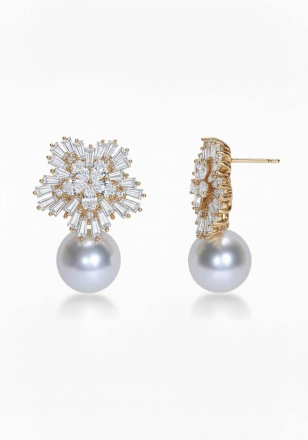 Pair of pearl earrings with gold and crystal embellishments on a white background