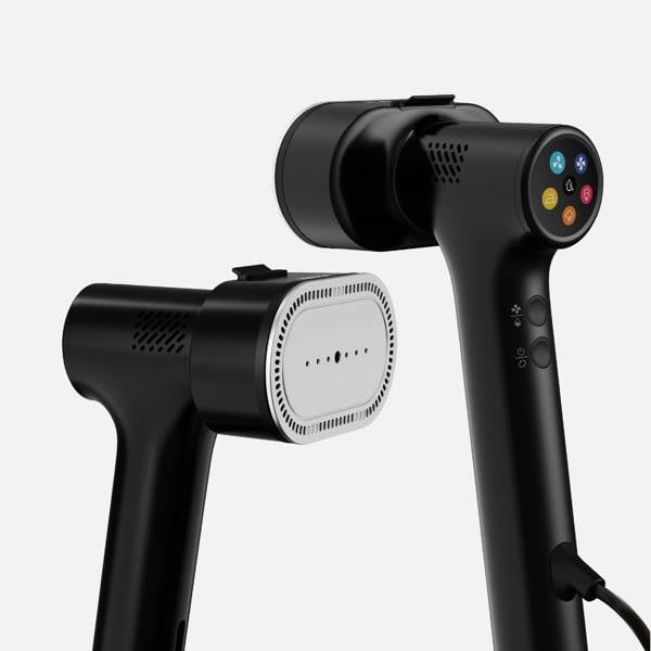 Two black Fridja f20 Handheld Clothes Steamer Pro with Suction units are shown. One highlights its metal steam plate, while the other displays its control panel with colorful buttons. Both garment steamers feature sleek, modern designs and are set against a plain light background—an ideal alternative to a traditional steam iron for effortlessly smoothing your clothes.