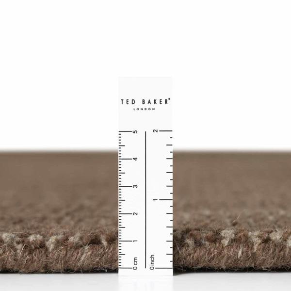 Brown carpet sample with a ruler for scale and 'Ted Baker London' branding.