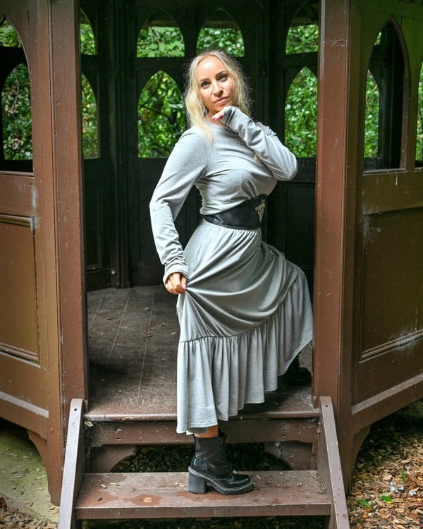 This is a young woman wearing a grey tiered skirt with a matching grey long sleeve. 