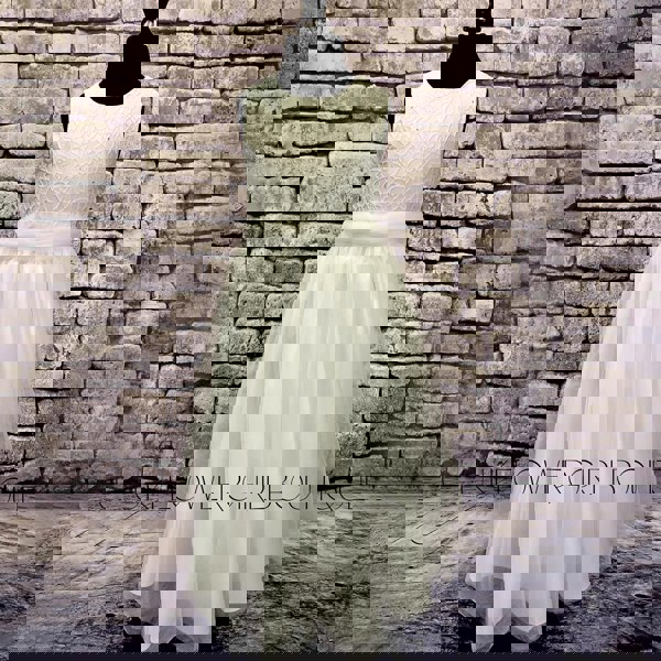 Isabella Flower Dress in with on a mannequin against a brick wall