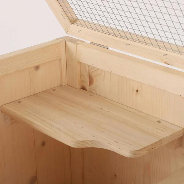 Natural wood interior platform shelf with open compartments inside a 4-tier cage