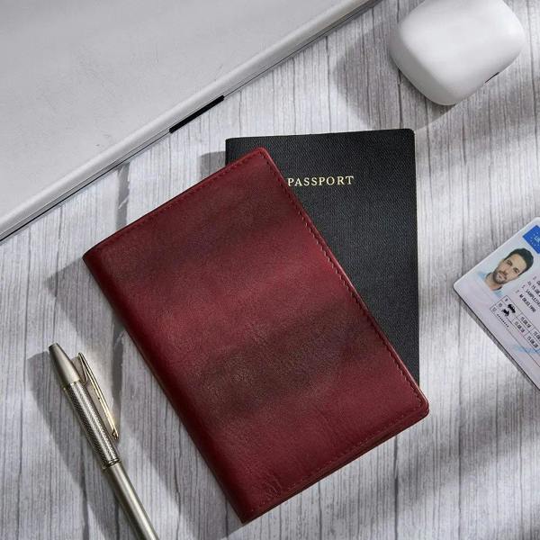 Bordeaux passport holder with a passport and pen on a wooden surface