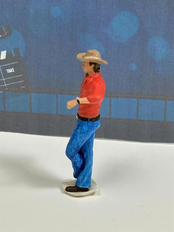 a toy figurine of a man wearing a cowboy hat