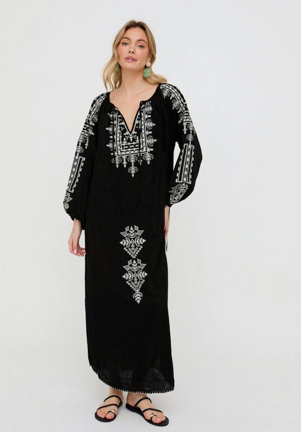 Woman wearing a black dress with white embroidery on a white background