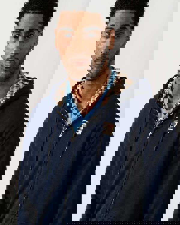 detail view of a model wearing an Aquascutum Mens Full Zip Badge Hoodie in Navy