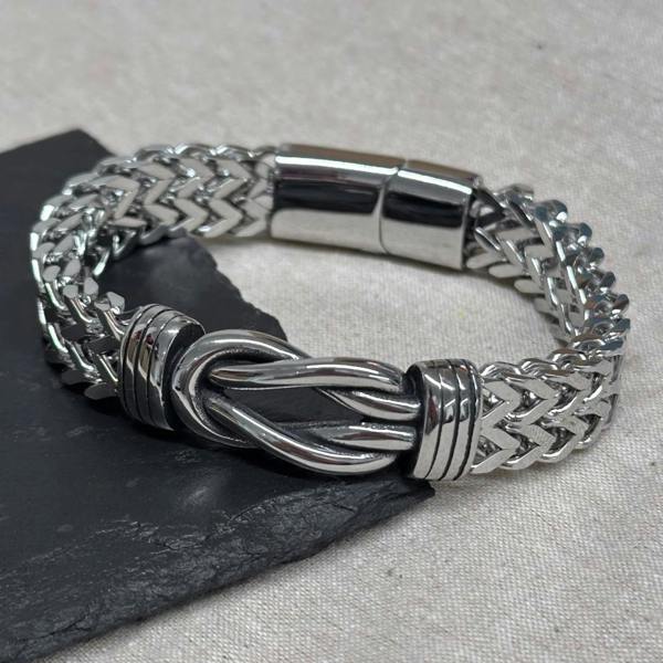 Custom engraved men's woven stainless steel infinity knot bracelet by Abode Home & Gifts worn on a male wrist.