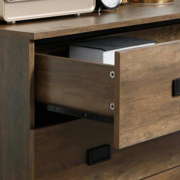 Brown dresser drawer interior with stacked papers and black pull handle detail