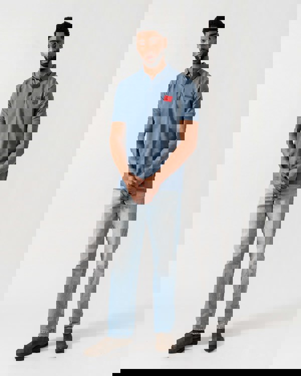 Model wearing HUGO Dereso222 Mens Cotton Piqué Slim-Fit Polo Shirt with Logo Label in Open Blue 496 - Full Length