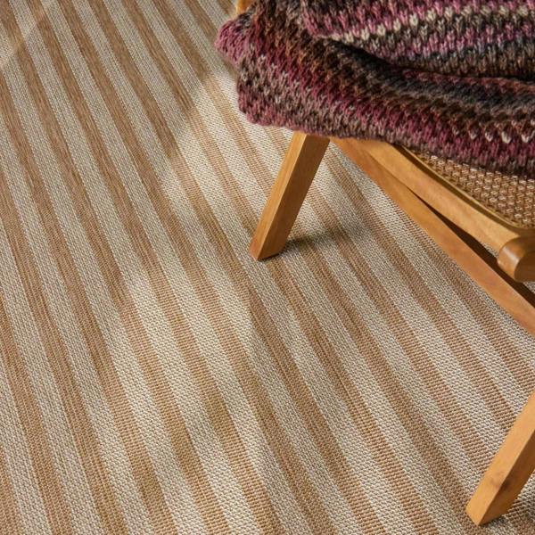 Striped carpet with a wooden chair and multicolored blanket