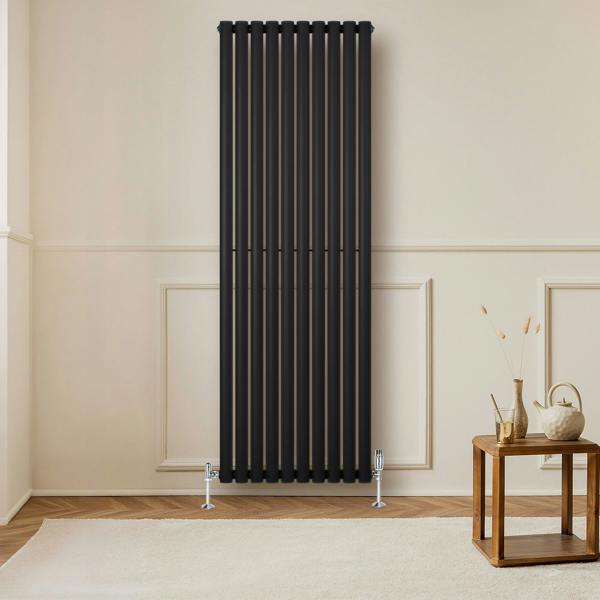 Sleek black oval single column radiator with vertical bars, complemented by stylish valves, enhancing a modern interior setting
