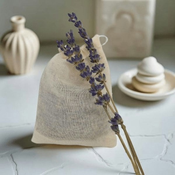 Textile bag with lavender on a light surface with decorative items in the background