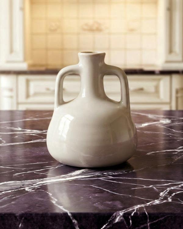 White ceramic jug on a marble kitchen countertop with blurred background
