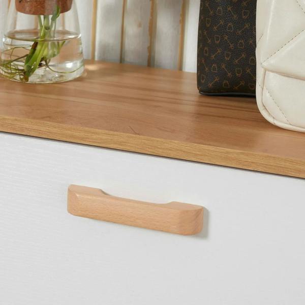 Wood-tone handle on white shoe cabinet drawer
