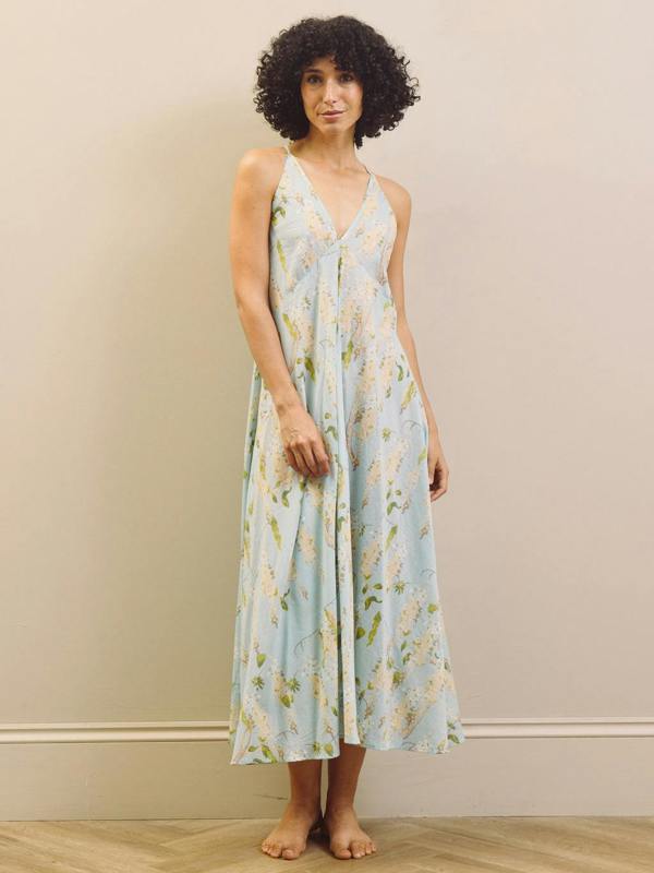 Woman wearing a floral nightdress against a plain background
