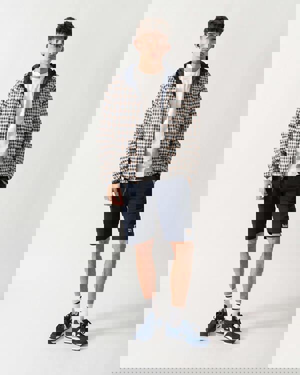 full length shot of a model wearing an Aquascutum Mens RLG Badge Reversible Sailor Jacket in Navy 11 showing reversed check pattern