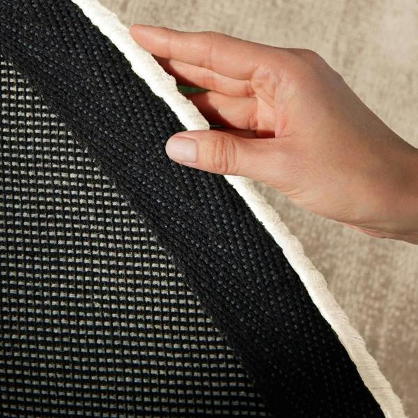 Hand holding a textured black and white fabric edge