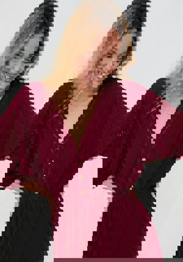 Woman wearing a burgundy dress with a white background