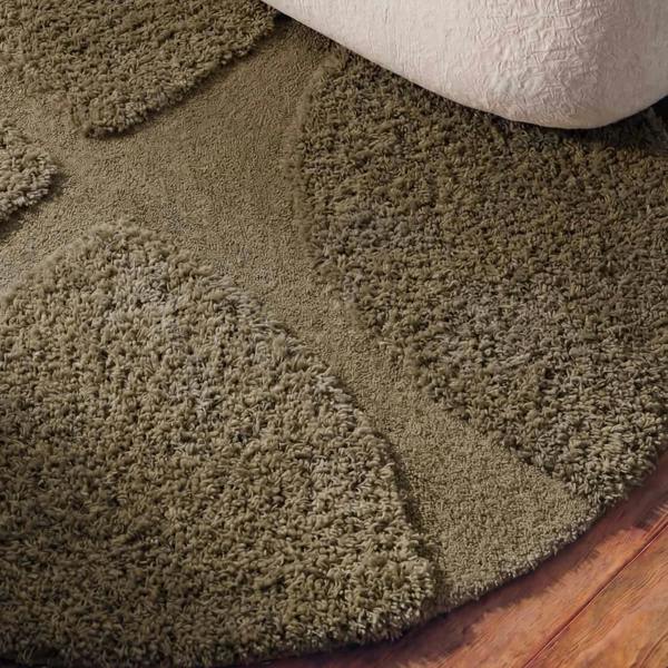 Brown shaggy rug on a wooden floor with a white baseboard.