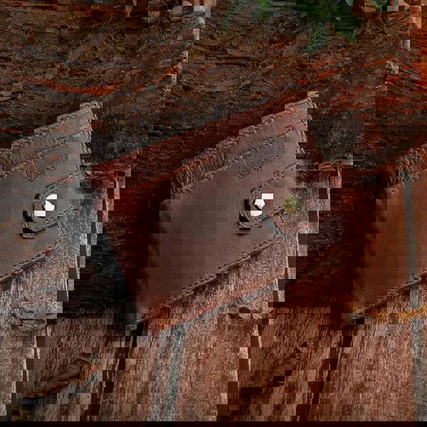 Brown leather wallet on a wooden surface with a rustic background