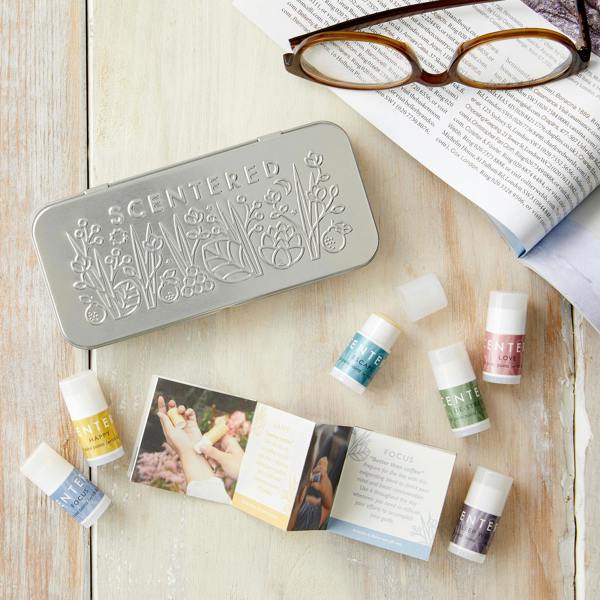 Collection of small balms, a box, and glasses on a wooden surface.