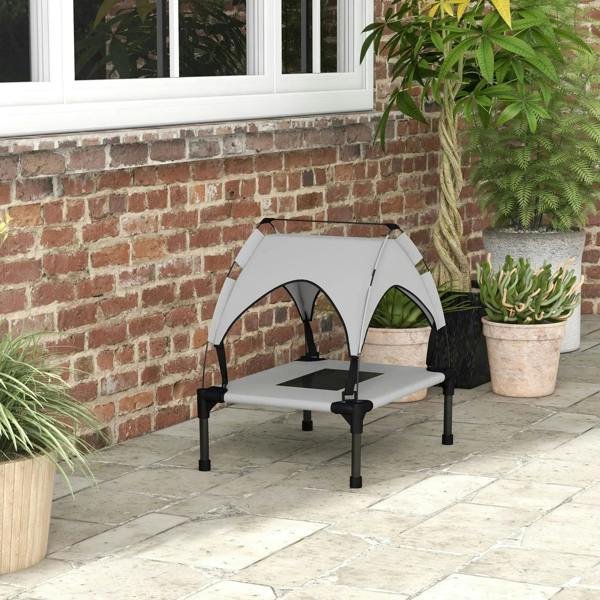 Light grey raised pet bed with canopy and breathable mesh panels on an outdoor patio