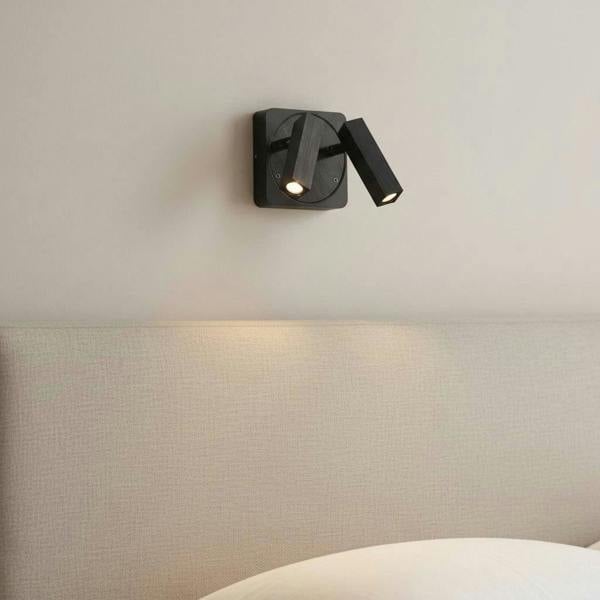 black over bed reading lamp mounted in a bedroom on the wall over a bed 
