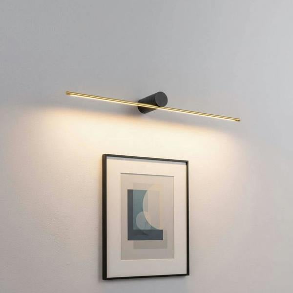 gold led picture lamp mounted over artwork on a wall