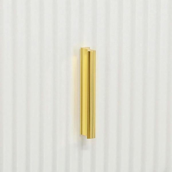 Gold bar handle on a white ribbed drawer front