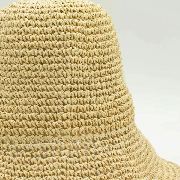 Natural beige straw hat close-up showing textured woven rows along the crown