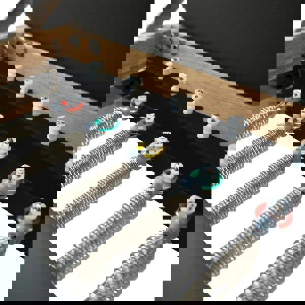 Close-up of the Pilates reformer machine in oak, showcasing the springs, adjustable settings, and sleek black upholstery