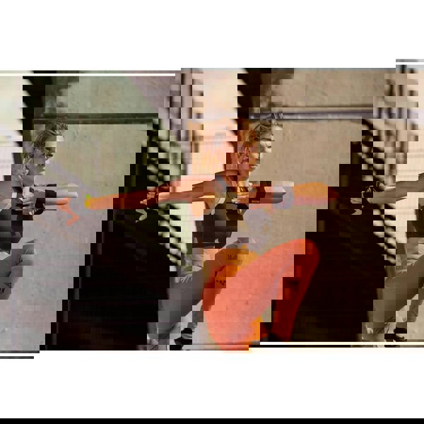 Woman in athletic wear training with the adidas ankle/wrist weights 0.5kg